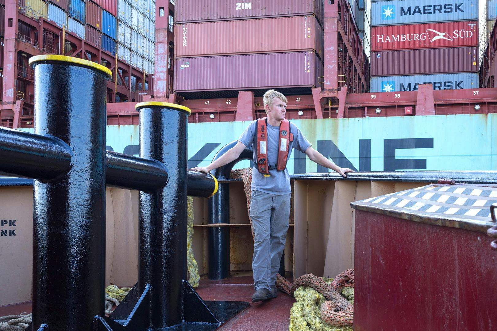 A deckhand on the bow of a McAllister tugboat