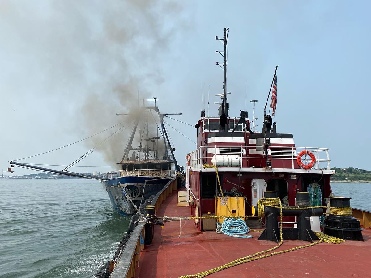 The Nancy McAllister safely guides a burning trawler to the dock in Portland harbor.